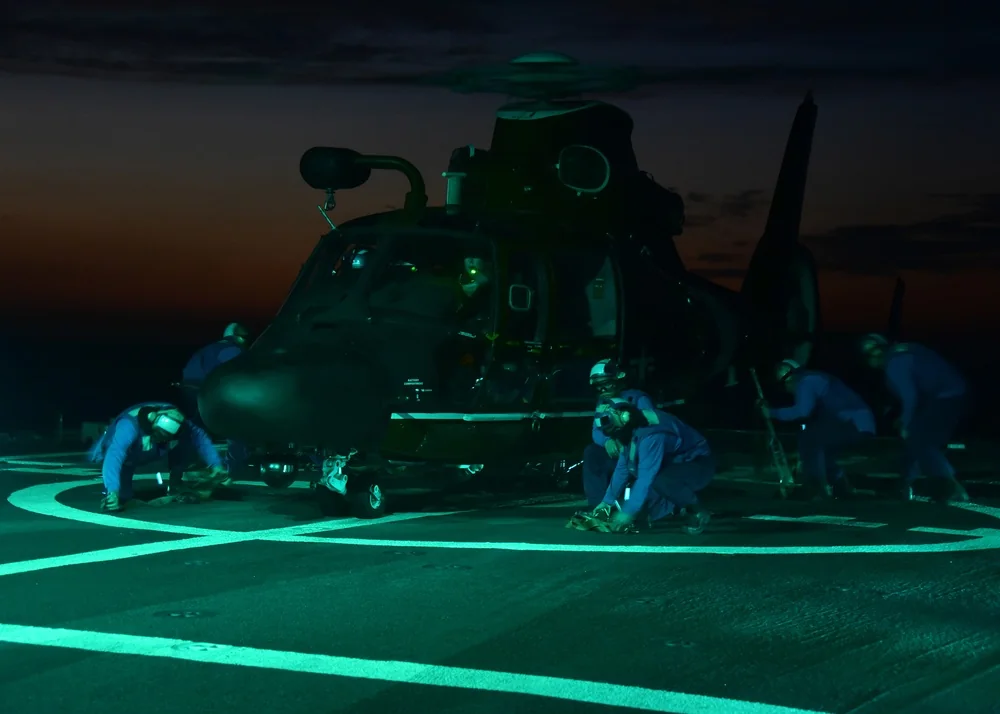 Preparing the MH-65 Dolphin for night work on the deck of a ship